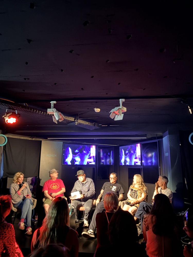 Six participants seated on stage during a roundtable discussion on Frankfurt’s techno history at MOMEM, with an audience watching in the foreground.
